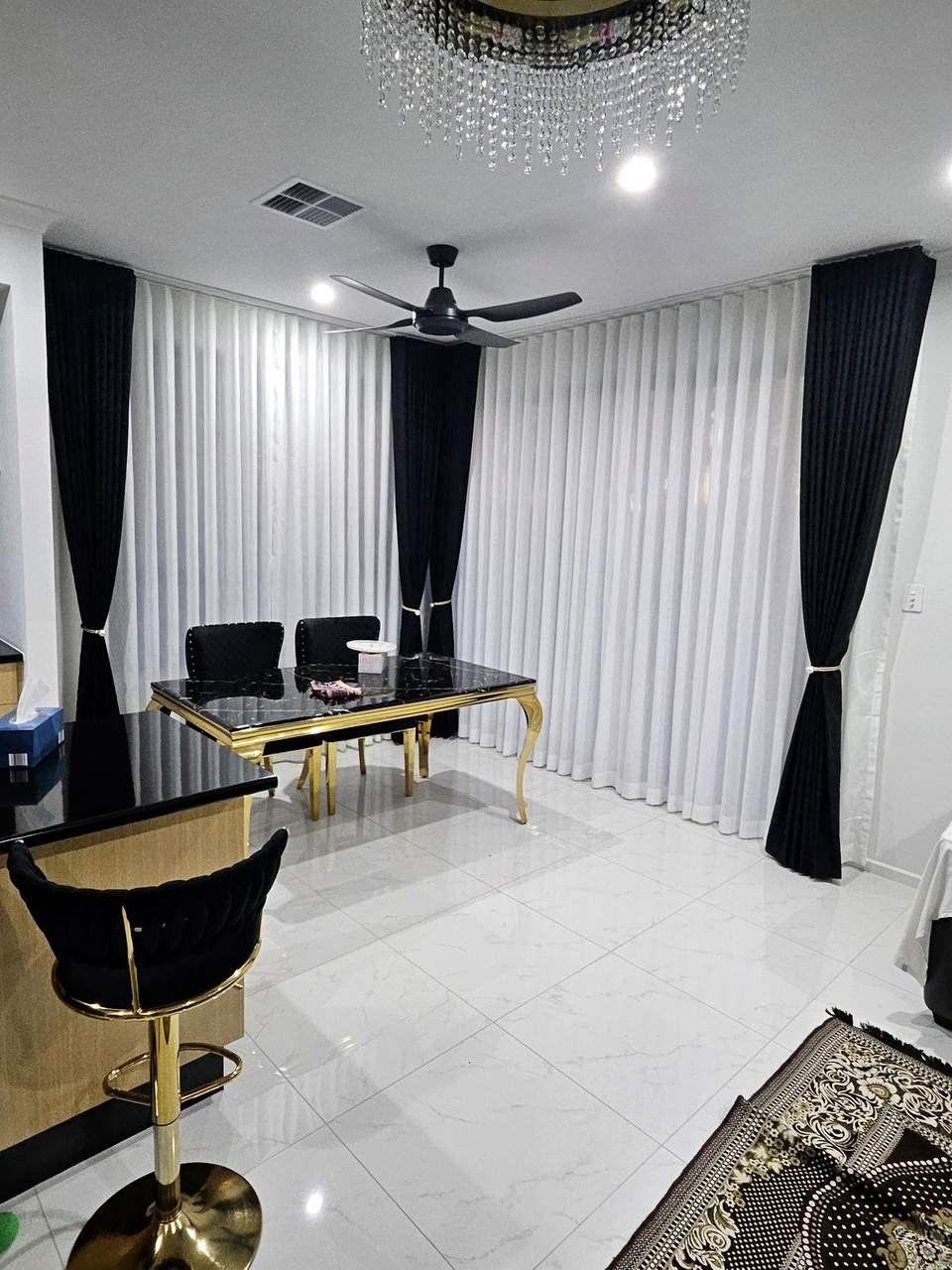 Black blockout curtains layered with white sheers in a dining room