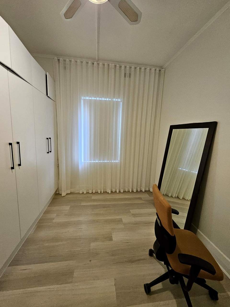 Blockout curtains in a bedroom with built-in wardrobes