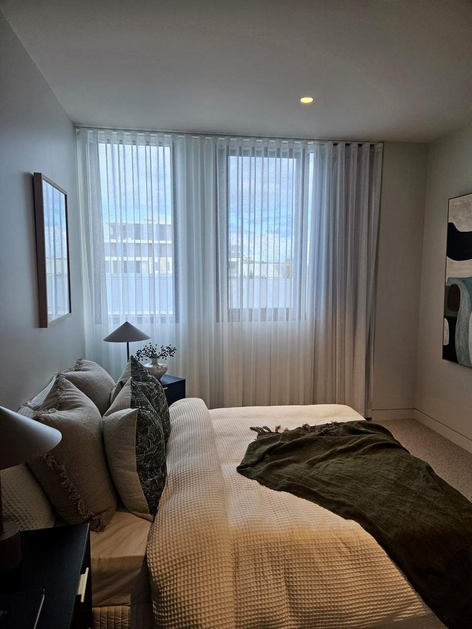 White sheer curtains in a bright display-home bedroom