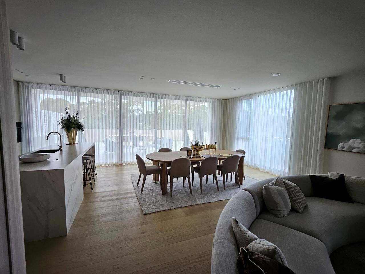 Sheer curtains across an open-plan kitchen and dining room