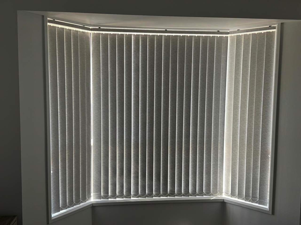 Vertical blinds fitted around a bay window