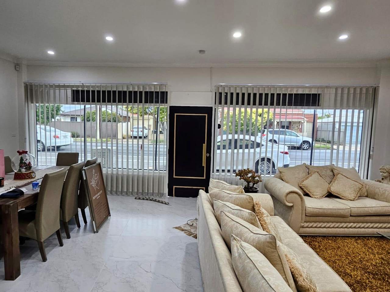Vertical blinds tilted open on large street-facing windows