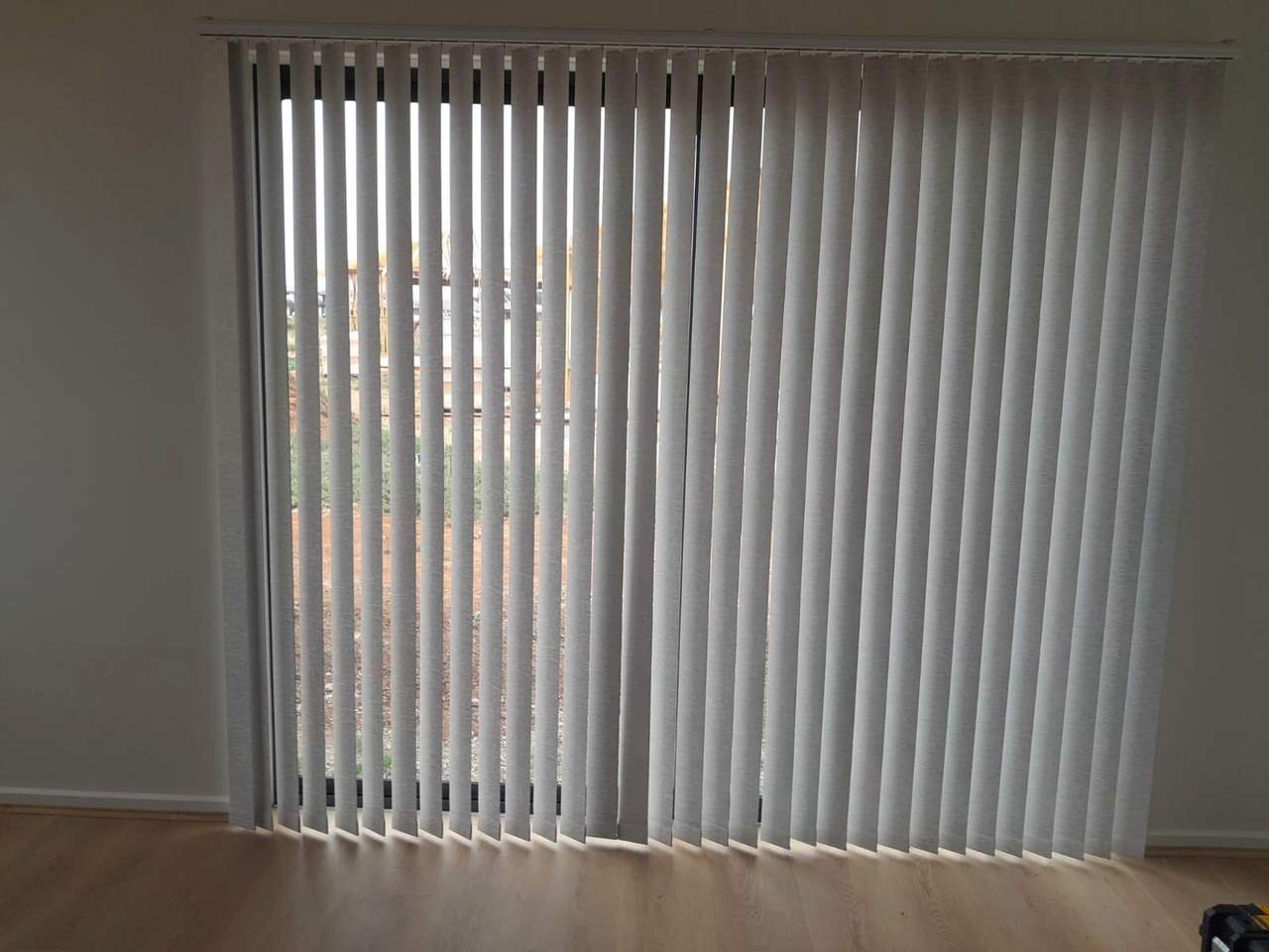 Textured grey vertical blinds on a large window